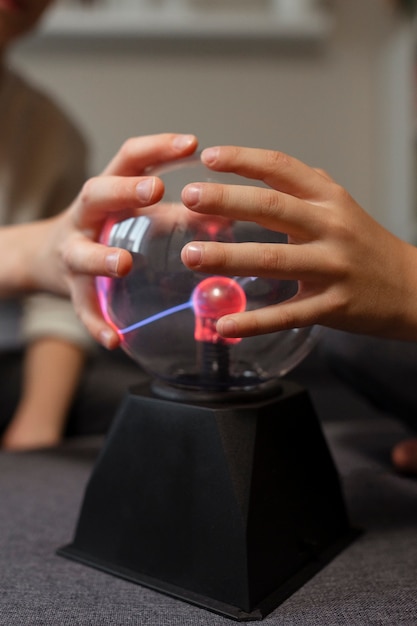 Niño interactuando con una bola de plasma.