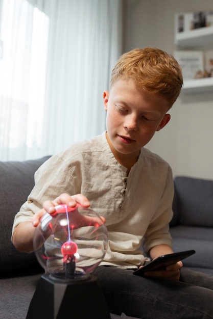 Foto gratuita niño interactuando con una bola de plasma.