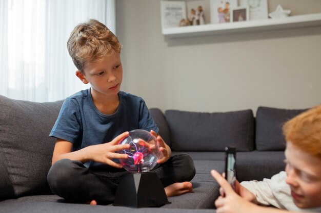 Niño interactuando con una bola de plasma.