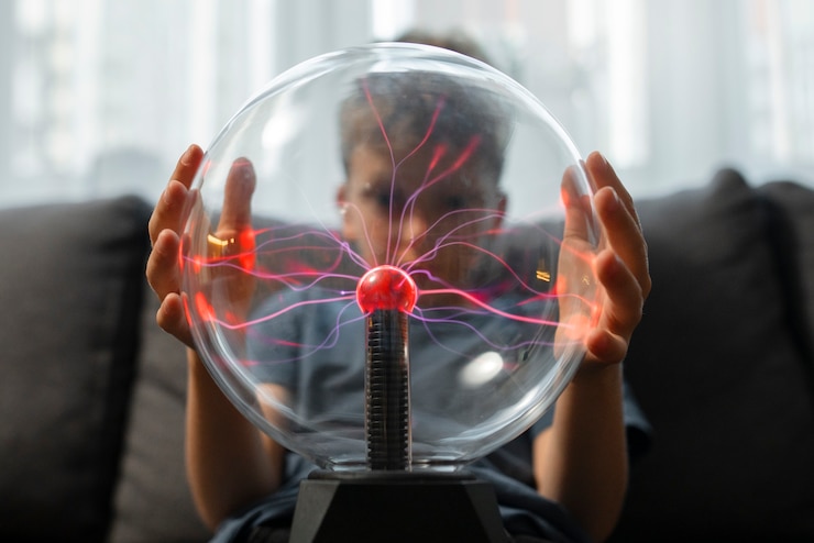 Foto gratuito niño interactuando con una bola de plasma.