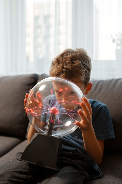 Niño interactuando con una bola de plasma.