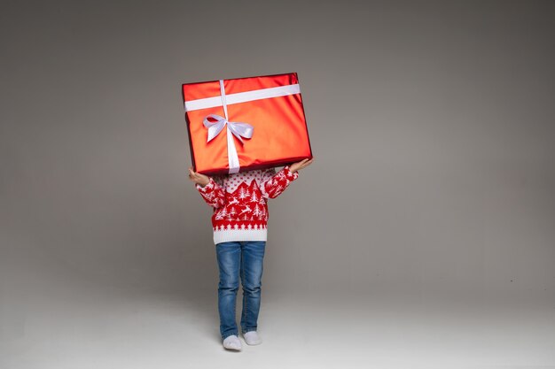 Niño irreconocible con regalo de Navidad