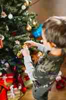 Foto gratuita niño joven decorando árbol de navidad