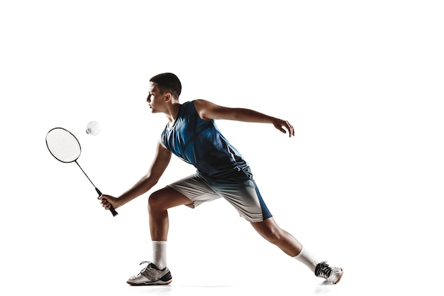 Niño jugando al bádminton aislado sobre fondo blanco.