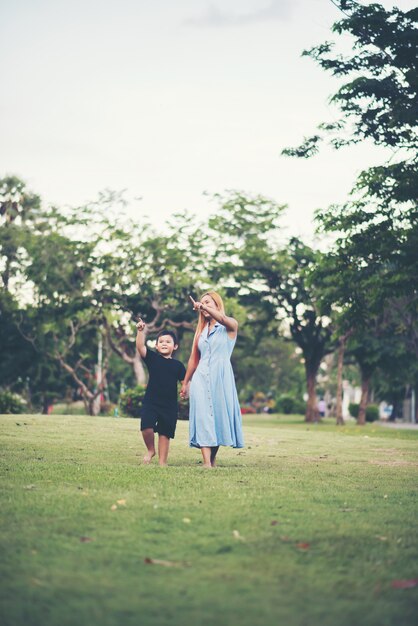 Niño jugando al fútbol soccer con la madre en el parque