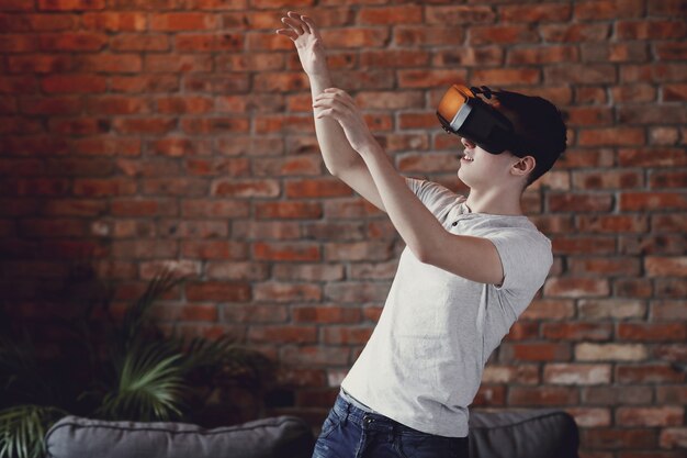 Niño jugando con auriculares VR en casa