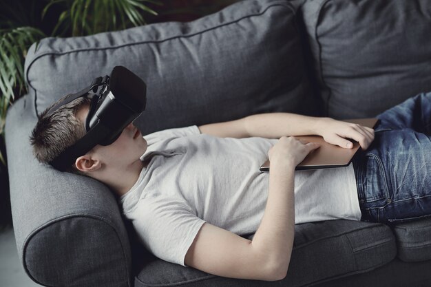 Niño jugando con auriculares VR en casa