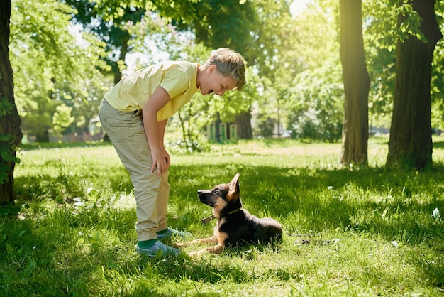 Niño jugando con cachorro en el parque de la ciudad verde