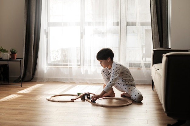 Niño jugando con carro de madera tiro completo