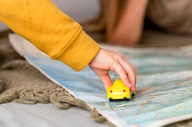 Niño jugando con coche de juguete en el mapa