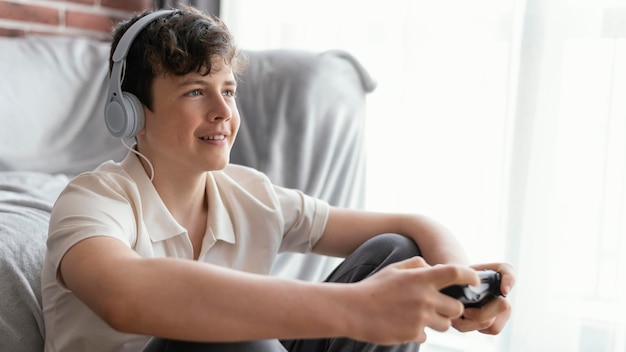 Niño jugando con controlador de tiro medio