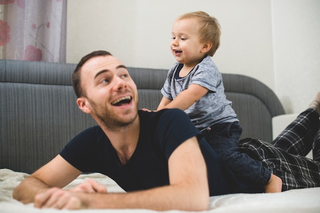 Niño jugando en la espalda de su padre