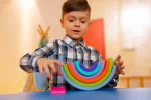 Foto gratuita niño jugando en el interior con juguetes ecológicos