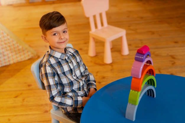 Foto gratuita niño jugando en el interior con juguetes ecológicos