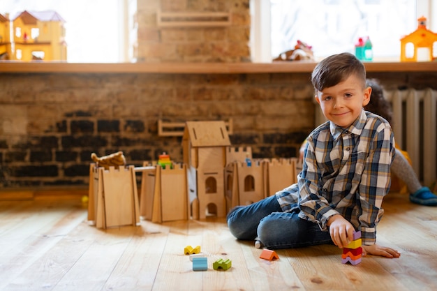 Foto gratuita niño jugando en el interior con juguetes ecológicos