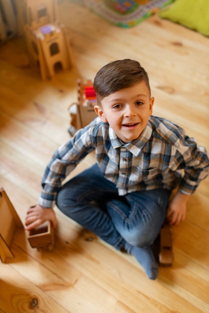 Foto gratuita niño jugando en el interior con juguetes ecológicos