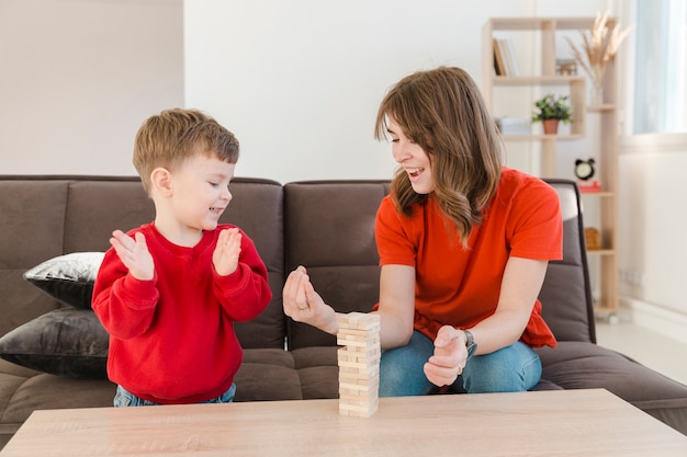 Foto gratuita niño jugando janga con su madre