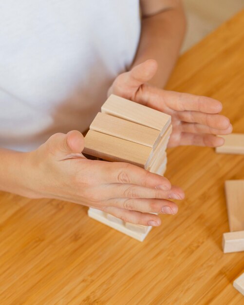 Niño jugando un juego de torre de madera en casa