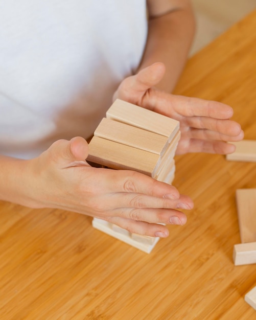 Niño jugando un juego de torre de madera en casa