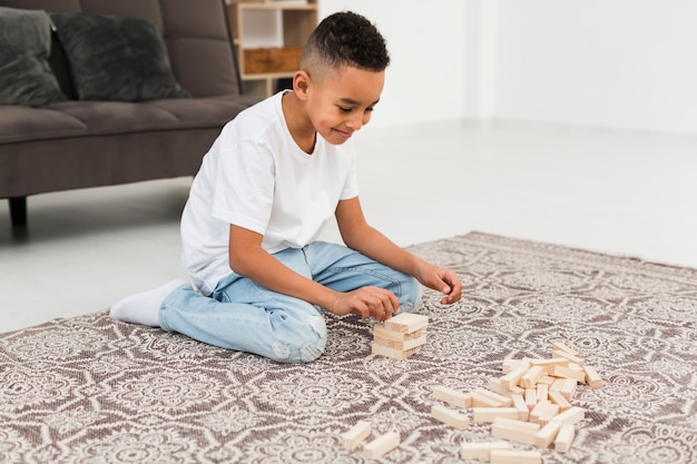 Niño jugando un juego de torre de madera