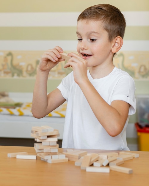 Foto gratuita niño jugando un juego de torre de madera