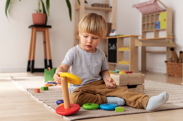 Niño jugando con juguetes de madera tiro completo