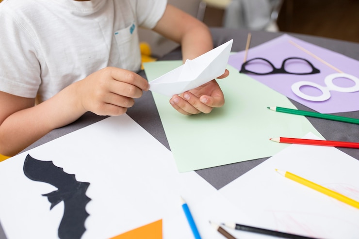 Foto gratuito niño jugando con papel en casa