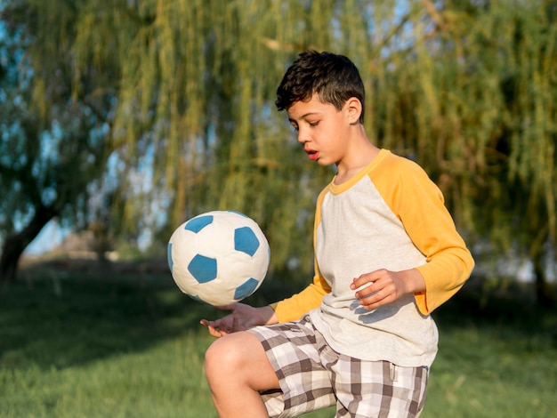 Foto gratuita niño jugando con pelota al aire libre