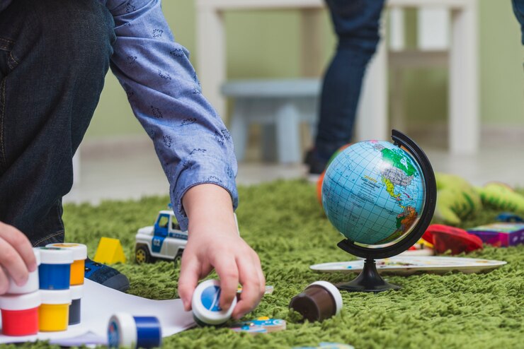 Foto gratuito niño jugando pinturas en el piso