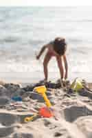 Foto gratuita niño jugando en la playa con juguetes.