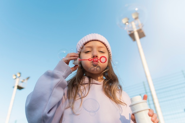 Foto gratuita niño jugando con pompas de jabón