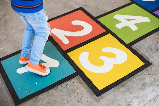 Foto gratuita niño jugando a la rayuela en la escuela