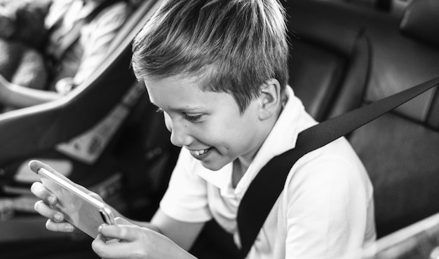 Niño jugando en un teléfono inteligente en el coche