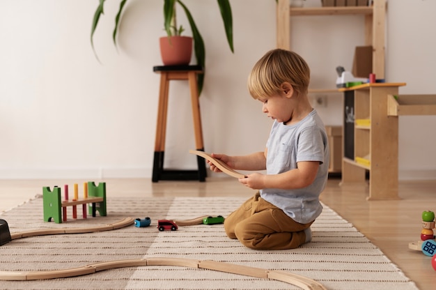 Niño jugando con tiro completo de juguete de madera