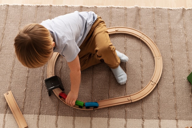 Foto gratuita niño jugando con tiro completo de tren de madera