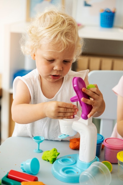 Niño jugando con tiro medio de juguete