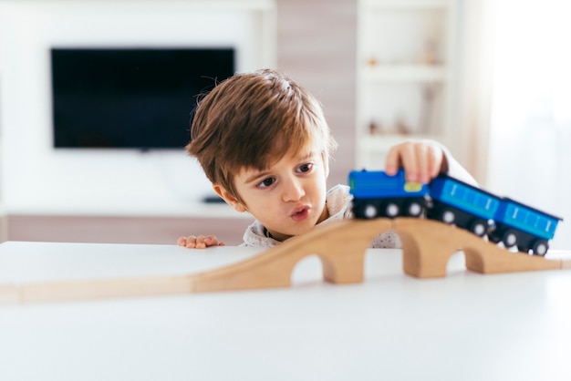 Niño jugando con tren de juguete