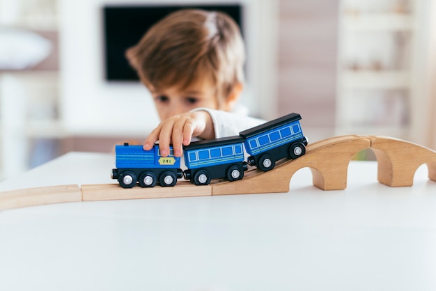 Niño jugando con tren de juguete