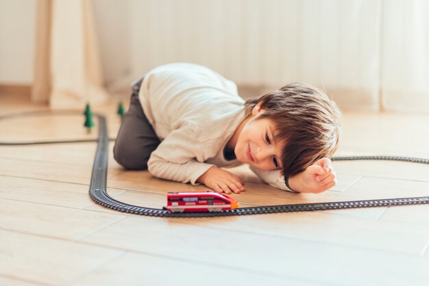 Niño jugando con tren de juguete