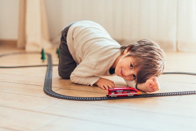 Niño jugando con tren de juguete