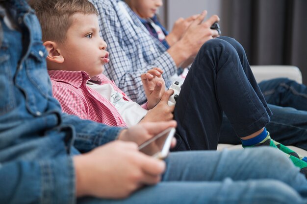 Niño jugando videojuegos cerca de los hermanos de la cosecha