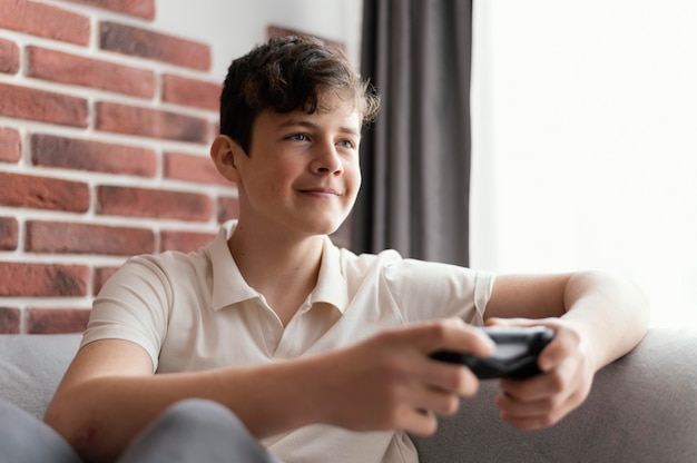 Niño jugando videojuegos tiro medio