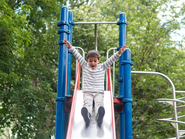 Niño jugando en la vista baja del parque