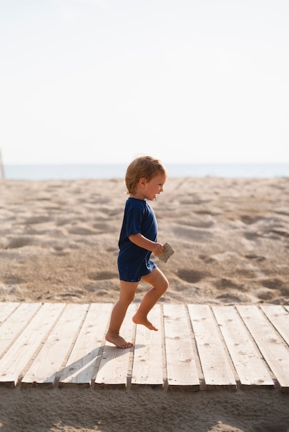 Niño juguetón corriendo en la playa