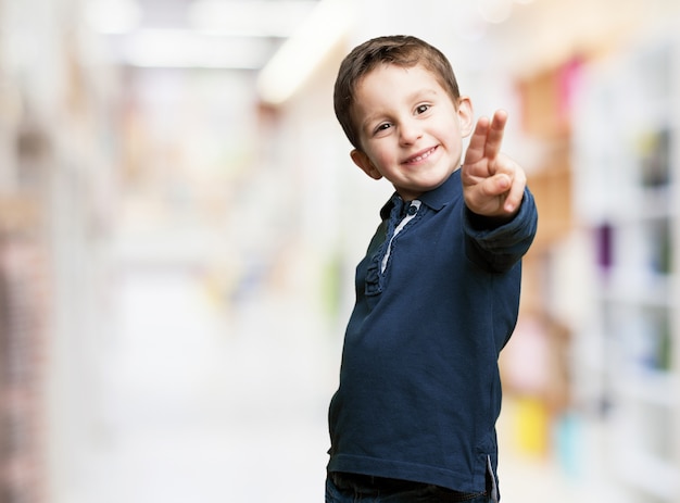 Niño juguetón señalando con dos dedos