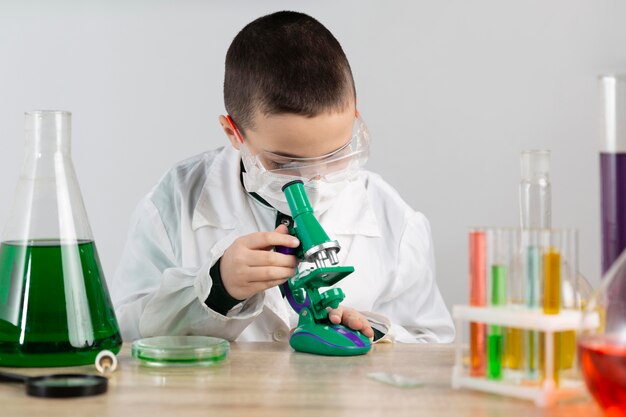 Niño en laboratorio con microscopio