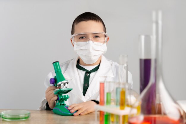 Niño en laboratorio con microscopio