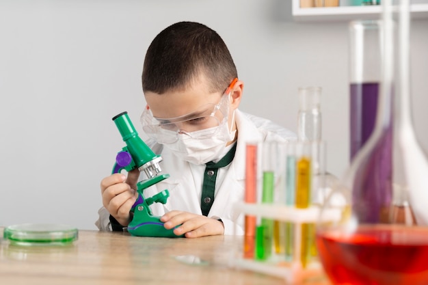 Niño en laboratorio con microscopio