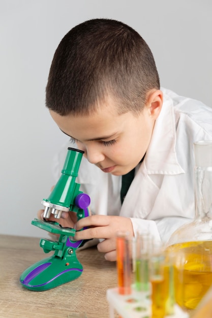 Niño en laboratorio con microscopio