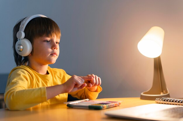 Niño de lado tomando cursos virtuales